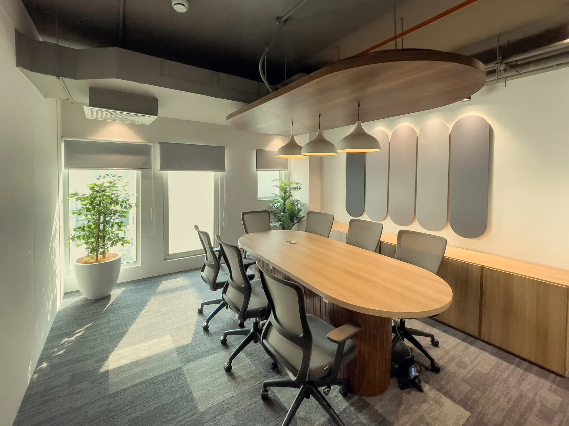 Boardroom at The Hive Karachi with an oval wood table and a pendant light