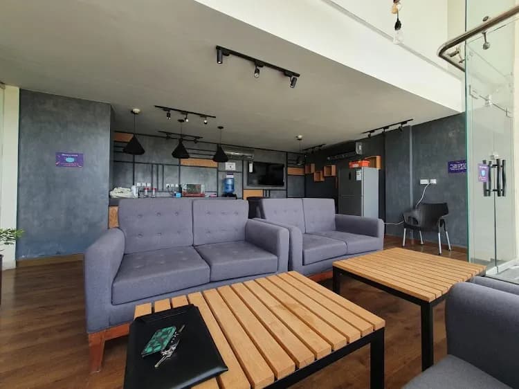 Lounge at The Hive Lahore with grey sofas and a wood coffee table