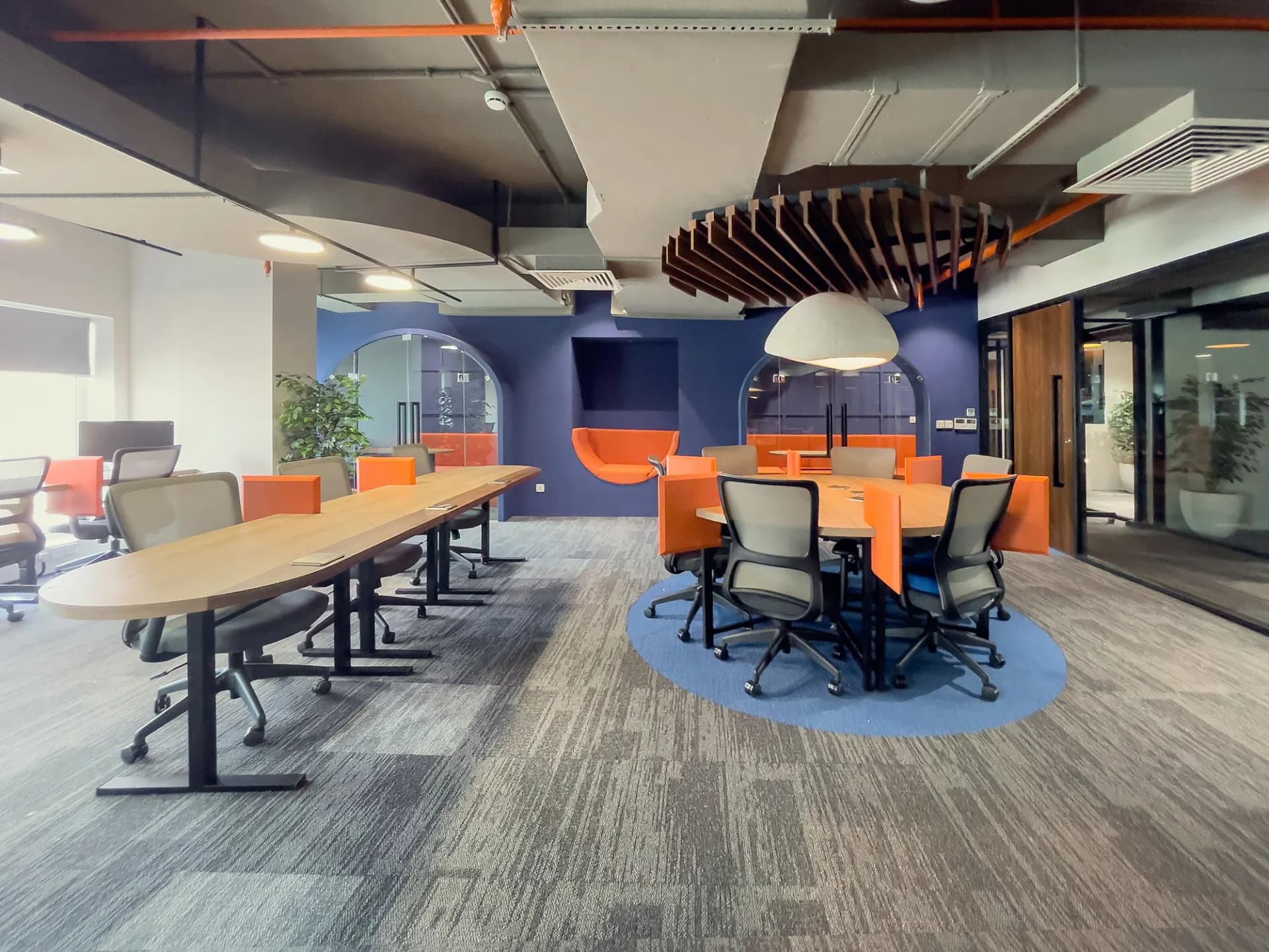 A furnished private office at The Hive with desks, chairs and a glass partition